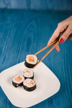 İştah açıcı Japonya, mavi ahşap arka planda izole bir tabakta yuvarlanıyor.