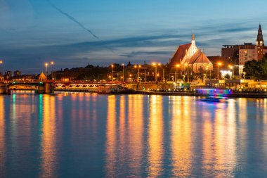 Szczecin. Nehrin karşısından aydınlatılmış tarihi merkeze gece görüşü. Odra Nehri. Szczecin 'deki Chrobry setleri