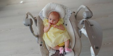 Bebek kız beşikte oyuncaklarla yatıyor.