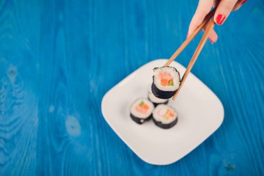 İştah açıcı Japonya, mavi ahşap arka planda izole bir tabakta yuvarlanıyor.