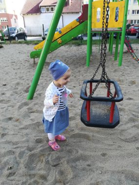 Annesiyle birlikte yatay barda asılı duran komik küçük bir kızın portresi.