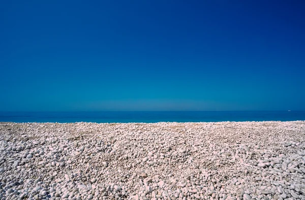 Kiezels op een rotsachtige strand in vertolkt — Stockfoto