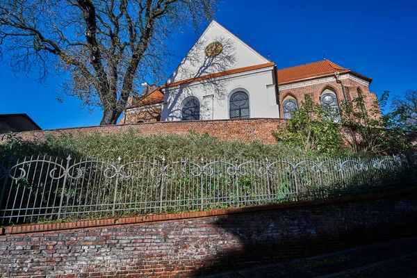 Baksteen, middeleeuwse muur en de gotische parochiekerk — Stockfoto