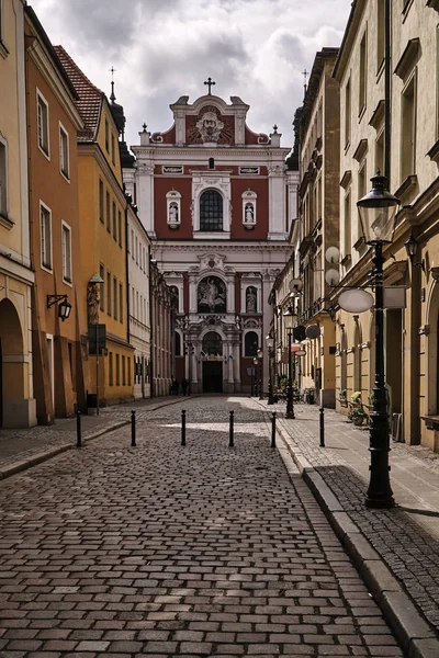 The cobbled street and the facade of the baroque church — Stock Photo, Image