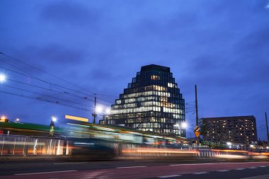 İkinci el, tramvaylar ve modern bir ofis Pozna içinde akşam Binası