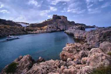 Rocky Körfezi Sahili ve Ortaçağ Kalesi Lindos şehrindeki bir kayanın tepesinde.