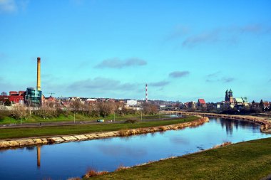 Poznan şehrinde warta nehri, endüstriyel bacalar ve katedral kuleleri