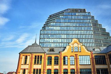 Eski bir matbaanın tarihi binası ve Poznan 'da modern bir ofis binasının cephesi.