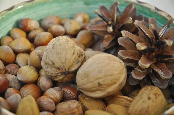 Walnoten, hazelnoten en amandelen in shells, één op de andere in keramische kom — Stockfoto