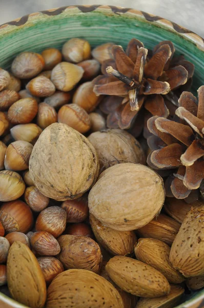 Walnoten, hazelnoten en amandelen in shells, één op de andere in keramische kom — Stockfoto