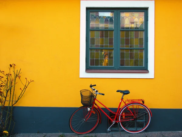 Sarı duvar ve kırmızı bisiklet ile güzel bir ev — Stok fotoğraf