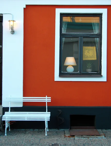 Prachtig gebouw met rode muur en witte Bank — Stockfoto