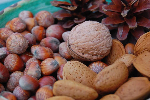 Walnoten, hazelnoten en amandelen in shells, één op de andere in keramische kom — Stockfoto