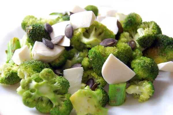 healthy lunch, broccoli with fresh mozzarella and pumpkin seeds