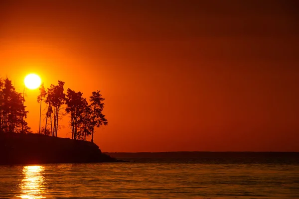 Schöner Sonnenuntergang am See mit Felsen und Kiefern — Stockfoto