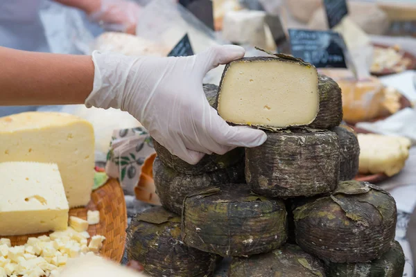 Marchand mains tenant du fromage sur le marché — Photo
