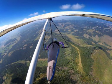 Hang glider pilot yüksek arazi üzerinde uçar