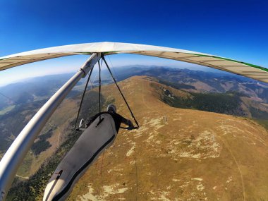 Slovakya dağlarında dağ üzerinde asılı planör pilotu uçar