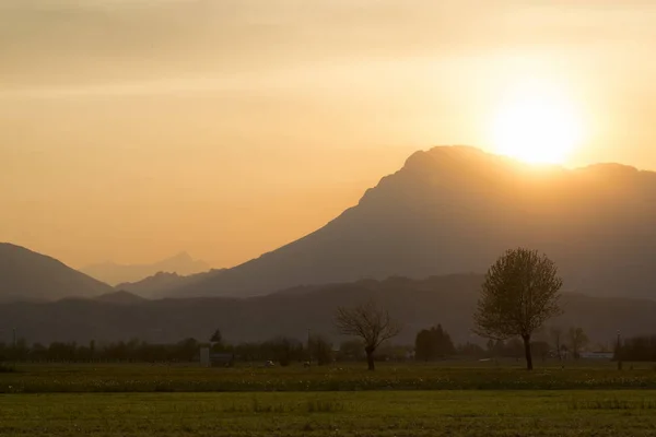 背景に高山の Meduno イタリアの農村地域における黄金の夕日 — ストック写真