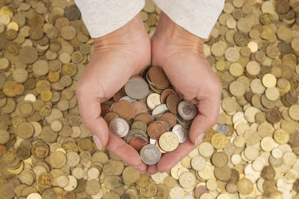 Manos humanas sosteniendo un montón de monedas — Foto de Stock