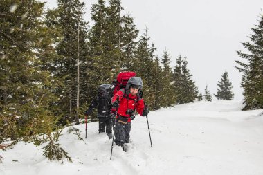 Yürüyüşçüler patikada, derin karda, yüksek dağlarda..