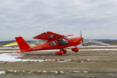 2020-02-09 Byshiv, Ukraine. Small red plane flies from local air clipart