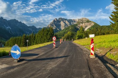 Yollar yüksek dağlarda işe yarar. Yol işaretleri ve güzel manzaralı dar alp yolu..