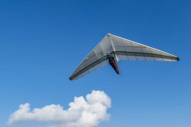 Hang glider wing and blu sky with white cloud. Dream of flying come true. clipart