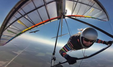 Askılı planör pilotu renkli kanatlarda kartalla birlikte uçuyor. Bir kuş gibi uçmayı hayal et. Vahşi doğada sosyal mesafeler diğer insanlardan çok uzakta..