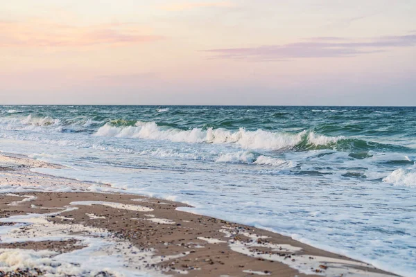 Amazing sunset at sea coast. Emerald sea waves of Black Sea, Ukraine. Empty beach because of quarantine