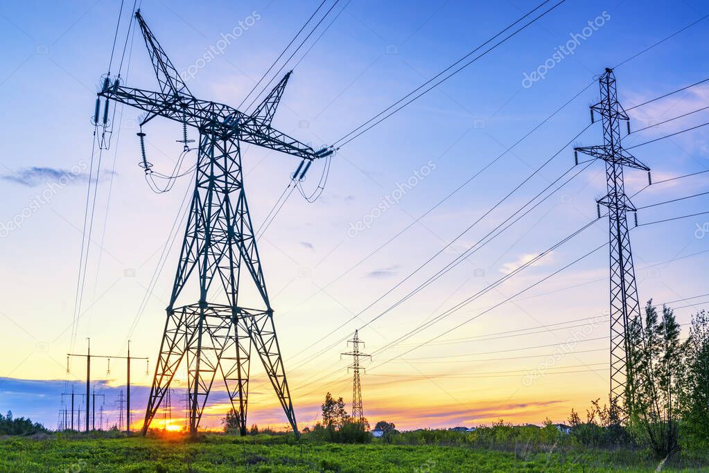 Industrial landscape with high voltage power lines at the sunset