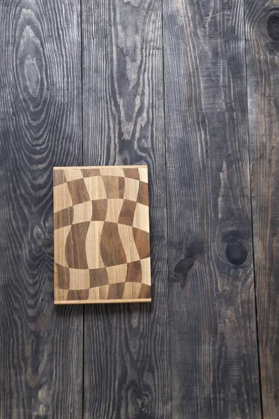 Tabla de cortar sobre una superficie de madera — Foto de Stock