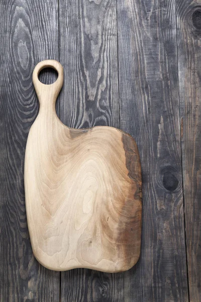 Placa de corte em uma superfície de madeira — Fotografia de Stock