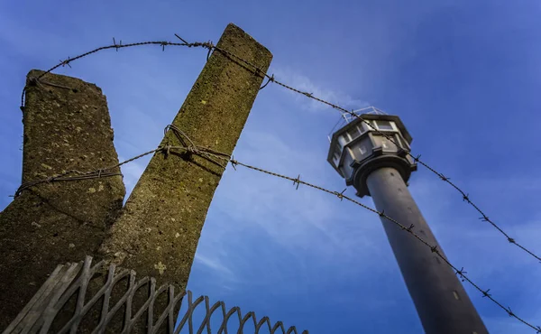 Taggtråd och vakttorn mot blå himmel — Stockfoto