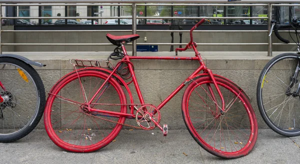 Ein altes rotes Fahrrad steht am Straßenrand — Stockfoto