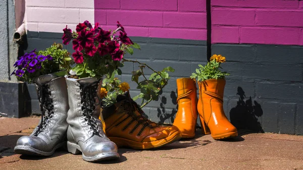Dekoracja kwiatowa w kolorowe stare buty — Zdjęcie stockowe