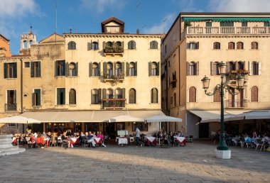 Venedik 'te tarihi evler, Doge Sarayı, gondolcu, gondolcu, su kanalları, turistler ve İtalya' daki lagün şehrindeki diğer manzaralar.