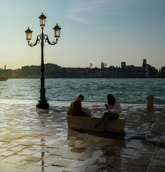 Am Wasser in VenedigTouristes assis au bord de l'eau à Venise — Photo