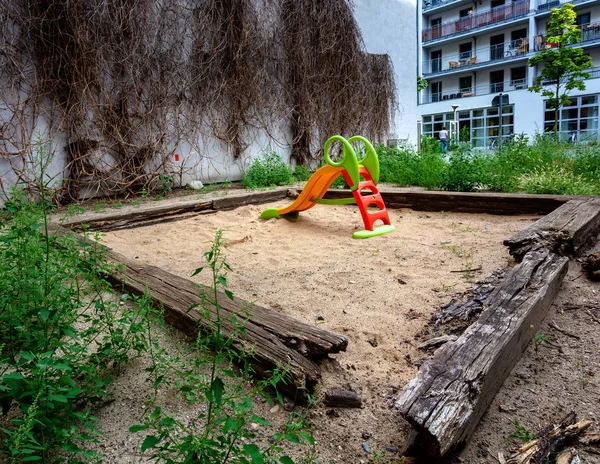 Piszkos homokozó egy luxuslakás-komplexum udvarán a berlini Mitte kerületben, Németországban — Stock Fotó