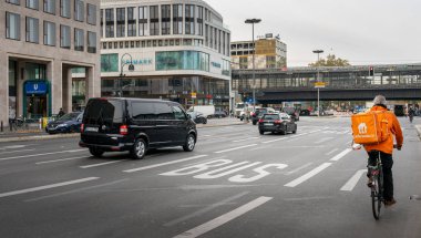 Berlin 'in yol trafiğinde otobüsler, arabalar, bisikletler ve yayalar