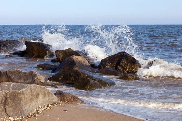 Group of stones on the shore and splashes from the waves — Stock Photo, Image