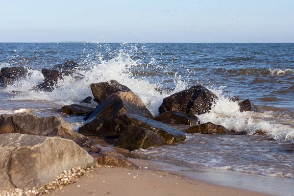 A group of stones on the shore and splashes from the waves — Stock Photo, Image