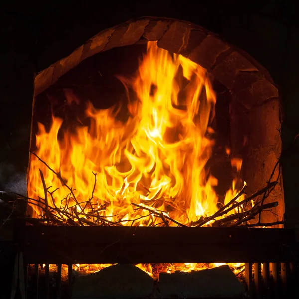 A bright and hot flame  in the opening of a stone fireplace — Stock Photo, Image