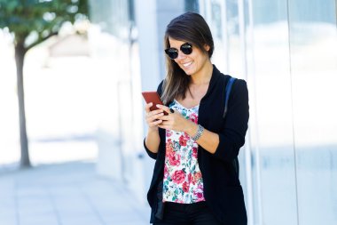 Sokakta cep telefonu kullanan güzel genç kadın.