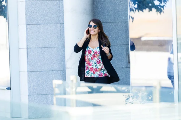 Hermosa joven usando su teléfono móvil en la calle . — Foto de Stock