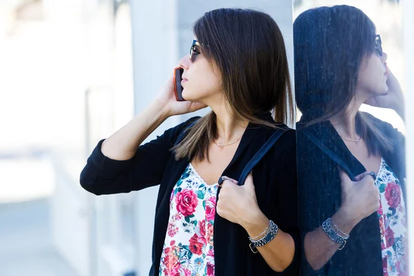 Krásná mladá žena pomocí svého mobilního telefonu na ulici. — Stock fotografie