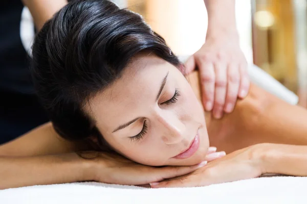 Beautiful young woman receiving a back massage in a spa. — Stock Photo, Image