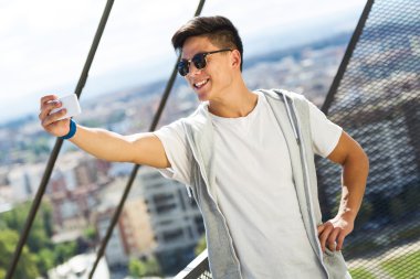 Güzel genç adam sokakta cep telefonunu kullanma.