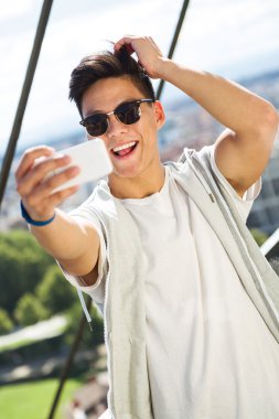 Güzel genç adam sokakta cep telefonunu kullanma.