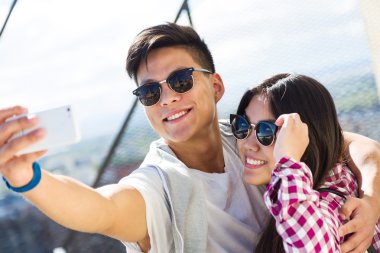 Cep telefonuyla şehirde mutlu genç Çift.